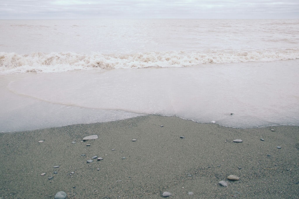 Waves criss crossing on a beach.