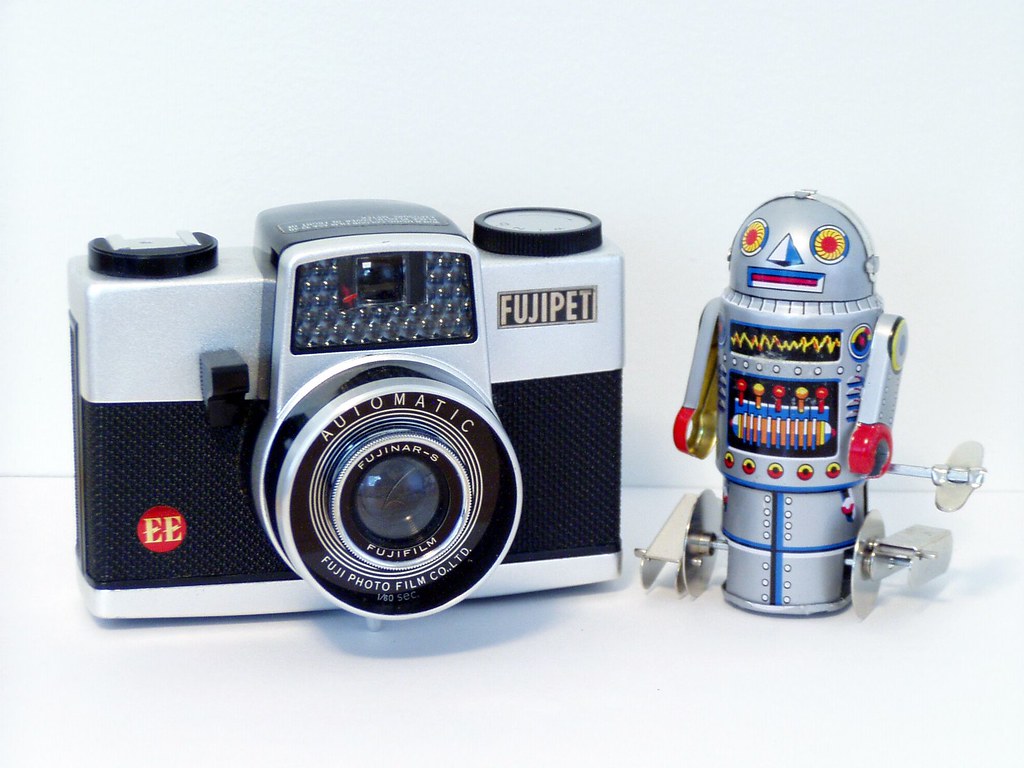 A plastic film camera and a small, wind-up robot.