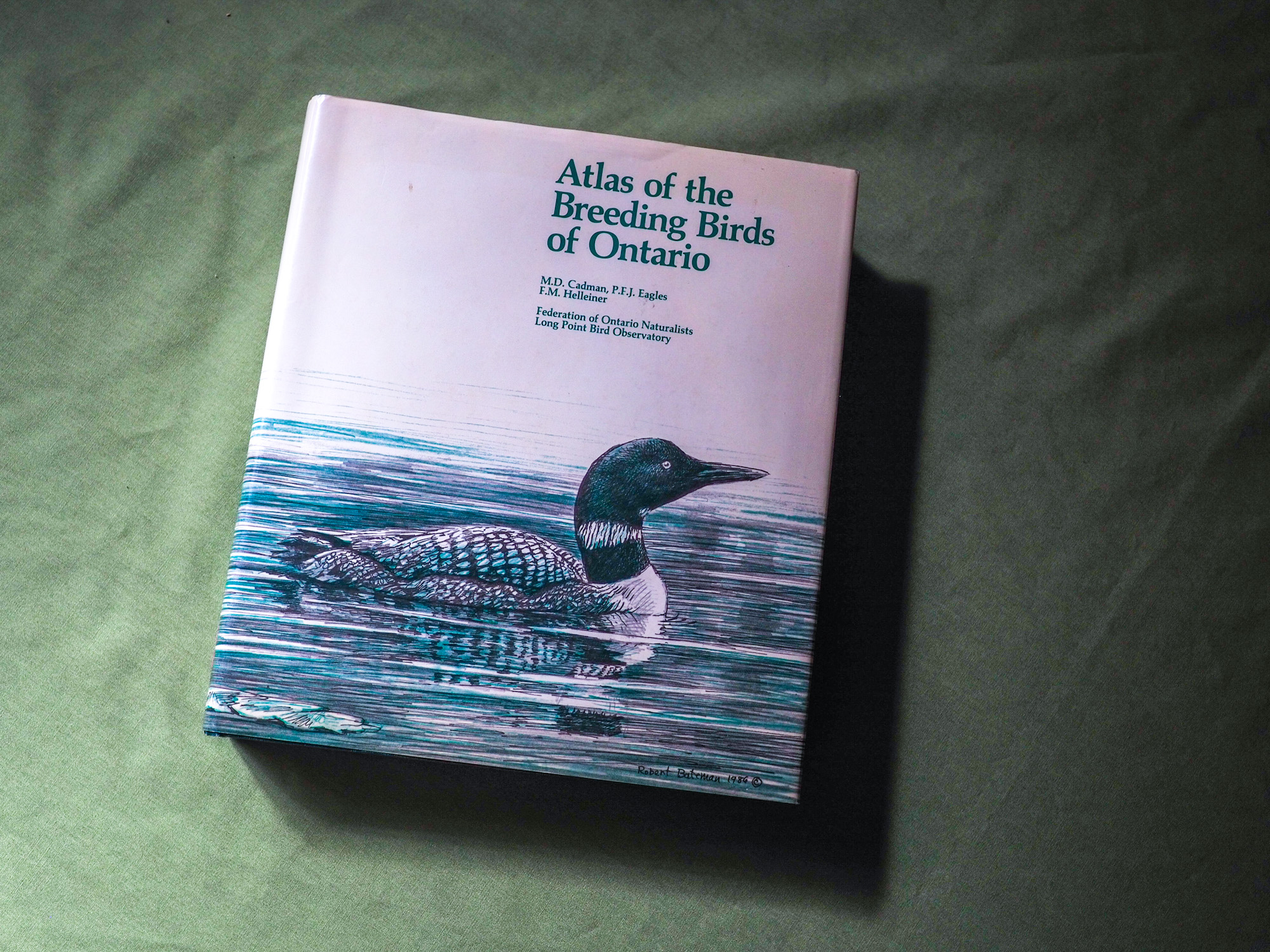 An atlas book with a picture of a loon on the cover.